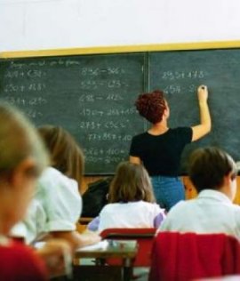 scuola: classe di alunni con maestra alla lavagna