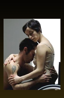 donna su una carrozzina abbracciata da un uomo 