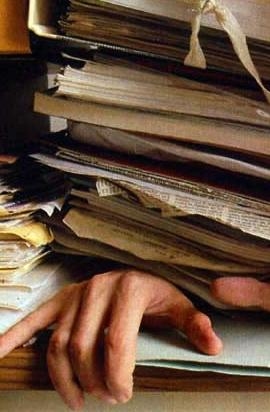 mano sepolta da una pila di scartoffie