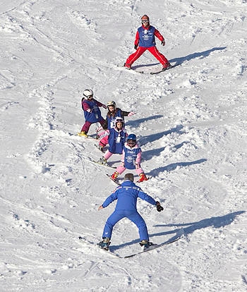 ragazzi e istruttori che sciano. Foto di "vacanza facile"