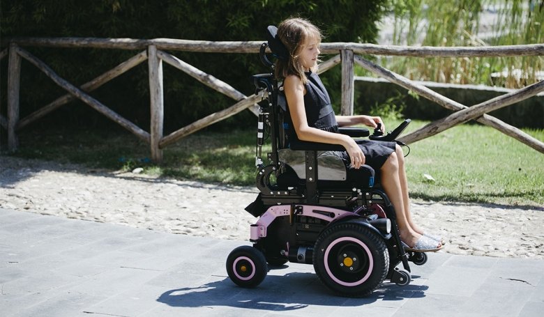 bambina al parco  abordo della carrozzina neatech evo1 