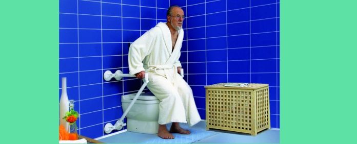 persona anziana si aiuta con maniglioni per alzarsi dal wc