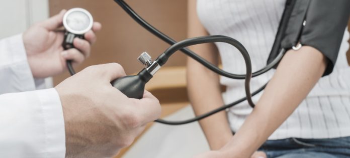 medico che sta misurando la pressione ad una sua paziente
