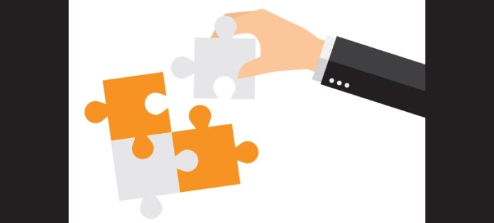 immagine di una mano che aggiunge un pezzo ad un puzzle