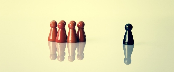 gruppo di birilli marroni e un birillo nero di lato fuori dal gruppo