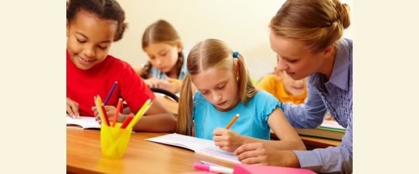 insegnante con bambini a scuola che aiuta una delle sue alunne