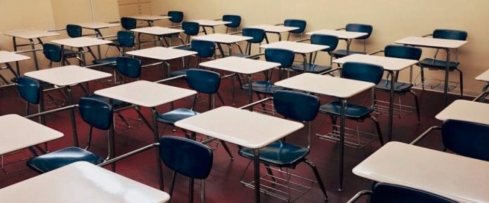 una classe scolastica con dei banchi vuoti