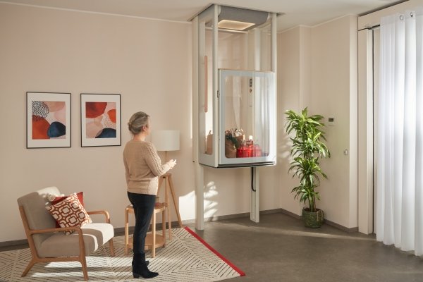 donna utilizza il miniasccensore per inviare al piano superiore una busta della spesa senza sforzo