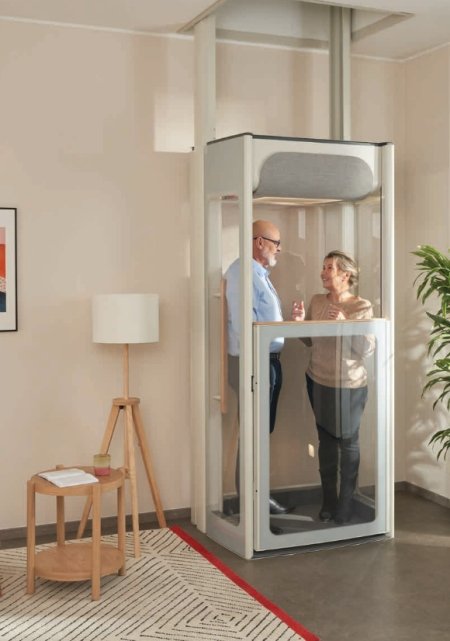 due persone anziane, un uomo  e una donna, dentro al miniascensore domestico