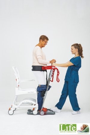 un'operatrice aiuta un'anziana ad alzarsi con il sollevatore