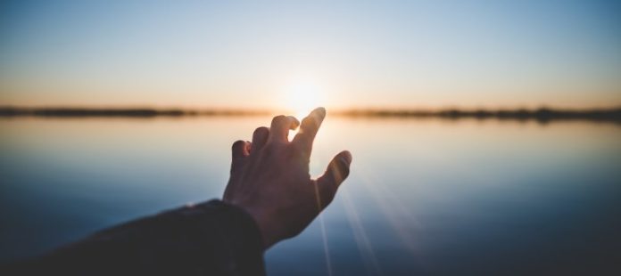 mano tesa verso il sole