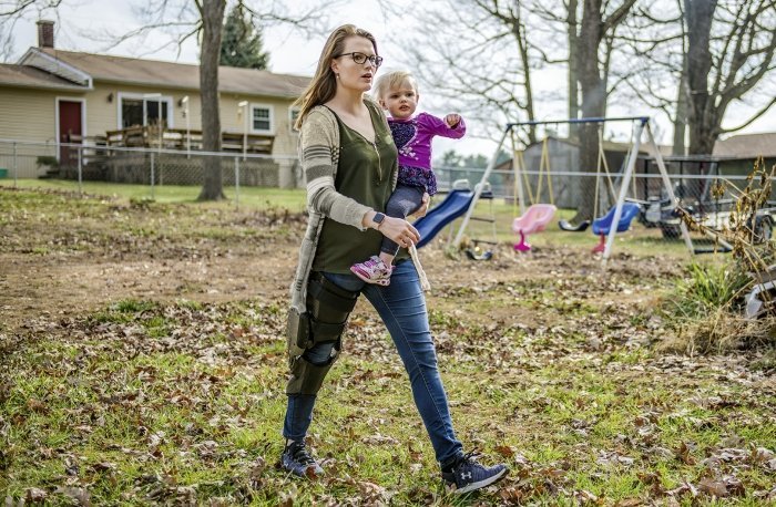 ragazza cammina con un bambino in braccio indossando la ortesi gamba C Brace di Ottobock