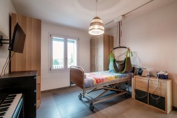 sollevatore posizionato accanto ad un letto all'interno di una stanza