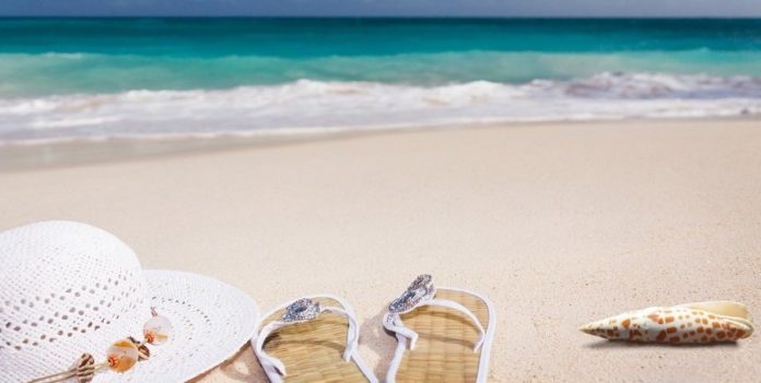 spiaggia soleggiata con infradito e cappello da mare