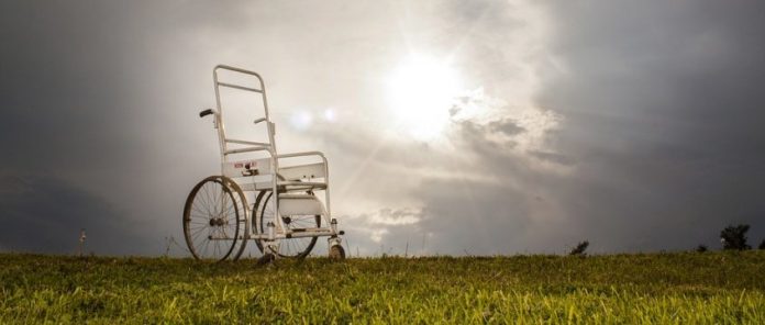 vecchia carrozzina manuale su un prato desolato