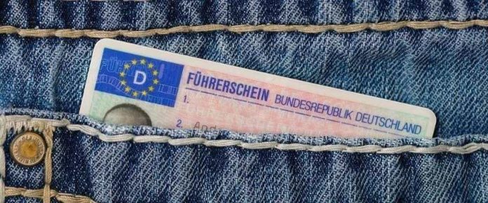 patente di guida spunta dalla tasca di un paio di jeans