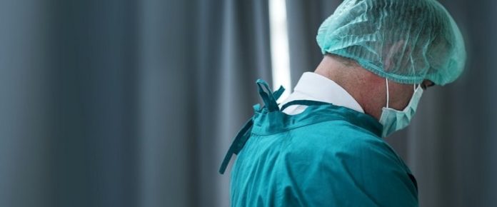 medico di spalle con mascherina anti-covid