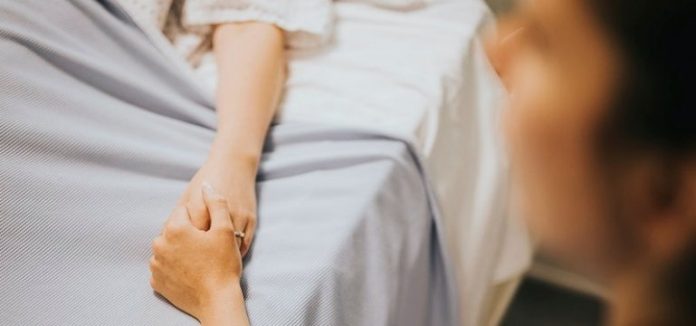 persona tiene la mano a qualcuno su un letto di ospedale