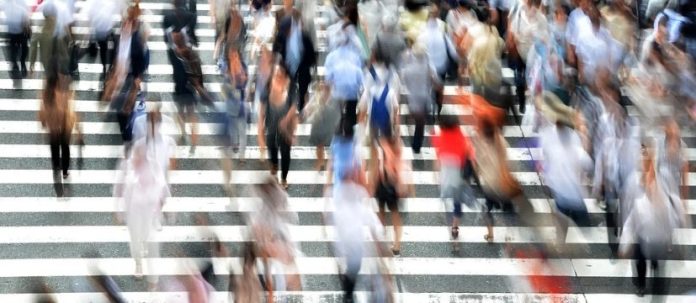 visione d'insieme sfuocata di molte persone in un attraversamento pedonale