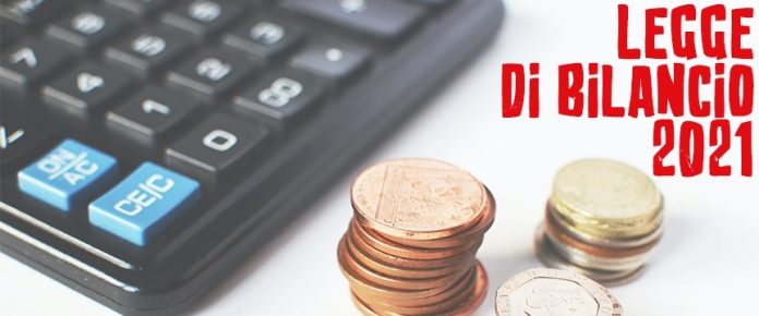 dettaglio di una calcolatrice vicino ad alcune monete e la scritta legge di bilancio 2021