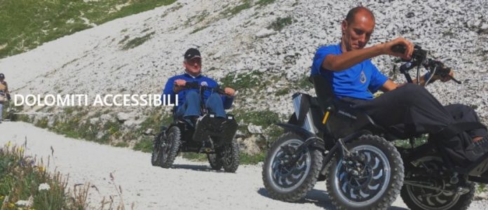 due persone in carrozzina in un sentiero delle dolomiti