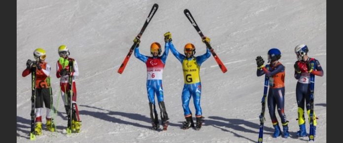 Bertagnolli e Ravelli esultano con gli sci in mano vicino a due altre coppie di sciatori