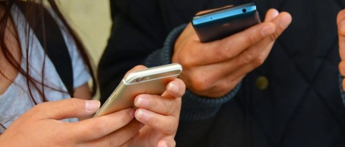 due persone stanno usando i rispettivi smartphone in mano