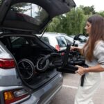 donna carica in bagagliaio una carrozzina richiusa