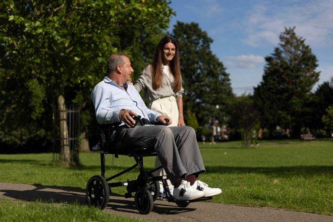 uomo insieme a una donna mentre passeggia sulla sua carrozzina elettrica