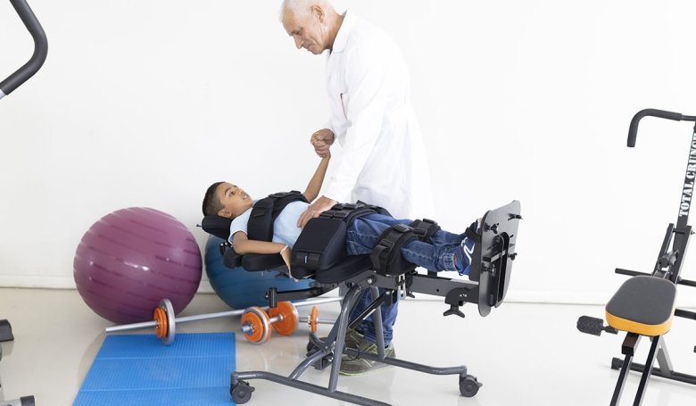 bambino in posisione supina mentre indossa lo stabilizzatore buddy brace steady vicino ad un uomocon camice bianco