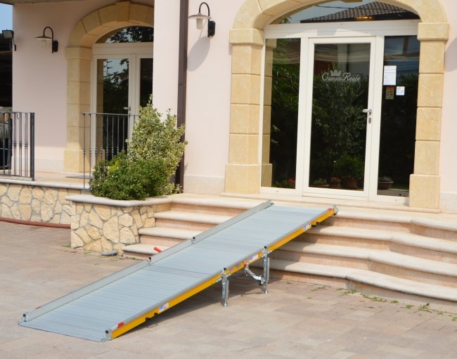 rampa d'accesso disabili su alcuni gradini davanti all'entrata di un edificio