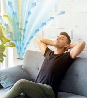 uomoseduto sul divano vicno al sanificatore d'aria