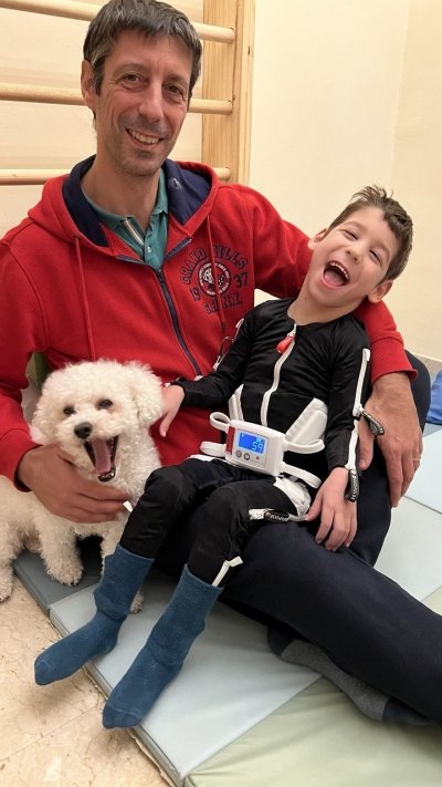 Fiodor con il papaà, vicino ad un cagnolino, mentre indossa la tuta Mollii