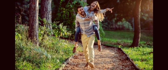 un ragazzo e una ragazza felici insieme durante una passeggiata nei pressi di un bosco