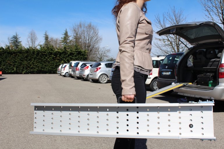 donna tiene in mano facilmente una rampa per disabili richiusa