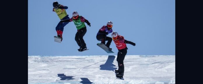 il salto di quattro snowboarder con disabilità durante una gara
