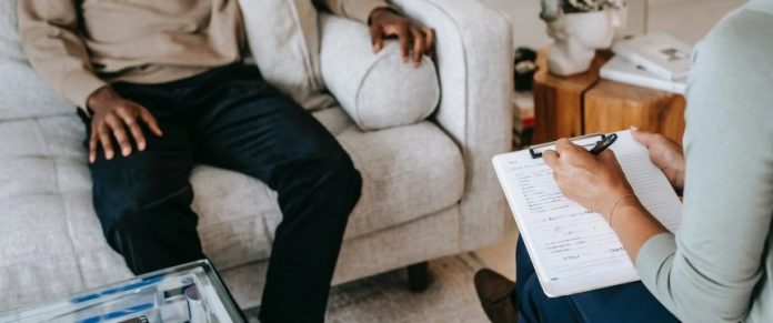 dettaglio delle mani di una persona seduta mentre parla con un medico