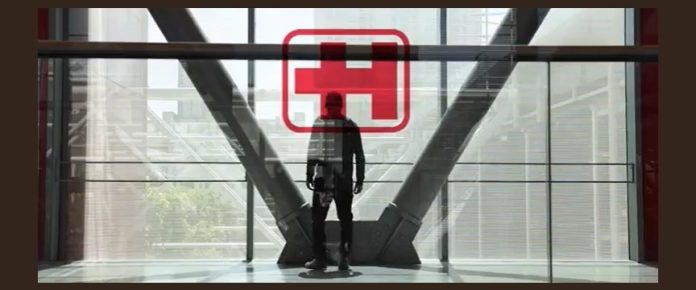 uomo di spalle davanti a una vetrata della fiera con il logo di exposanità