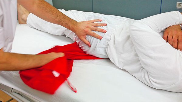 dettaglio delle mani di una persona che sta movimentando un utente allettato per cambio posizione