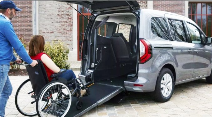 uomo spinge a bordo del kangoo allestito una donna seduta in carrozzina, tramite la rampa di accesso al veicolo