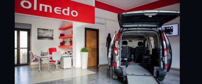 interno di un olmedo point con un mezzo allestito per trasporto carrozzine, vicino ad un'area ufficio