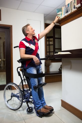 uomo in carrozzina in posizione eretta, grazie alla funzione di verticalizzazioneili in piedi