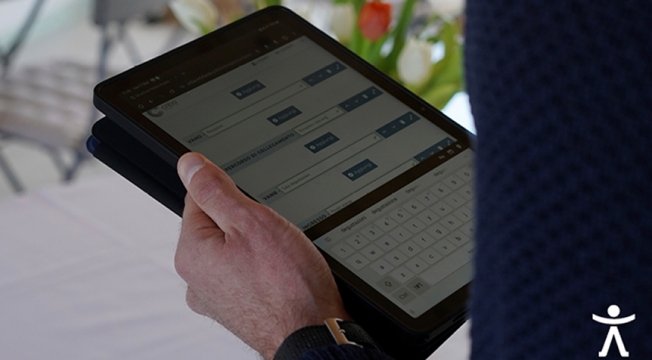 dettaglio del tablet che un uomo sta utilizzando per prenotare una vacanza