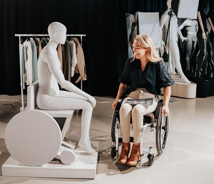 l'attivista inglese Sophie Morgan posa vicino ad un manichino di una persona in carrozzina, realizzato da Primark con la ua collaborazione