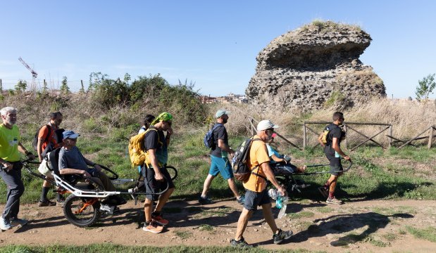 alcuni partecipanti della camminata di pari passo sull'appia antica, tra cui una persona disabile trasportata da altre persone su una joelette