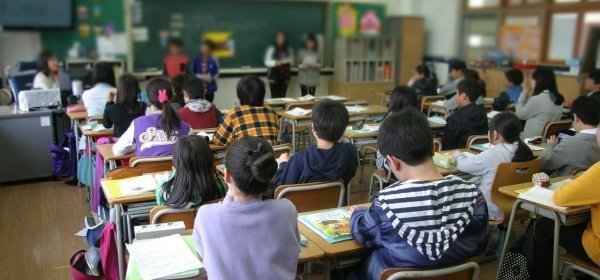 in un'aula, ragazzini di scuola media seduti ai loro banchi, durante una lezione