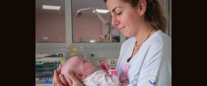 infermiera tiene in braccio un neonato