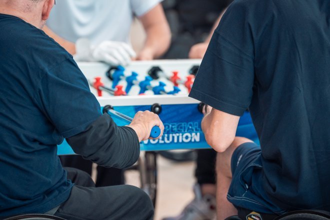 persone in carrozzina mentre giocano a calcio balilla