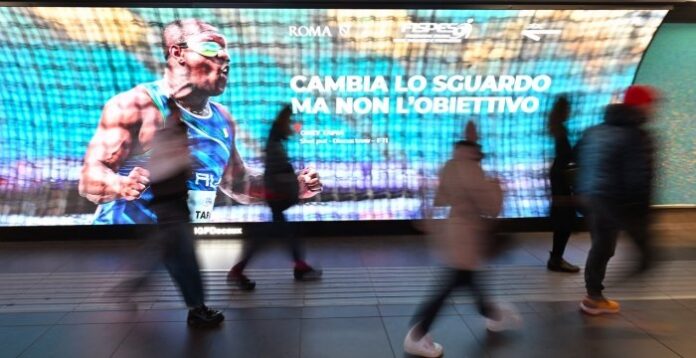 foto del campione paralimpiaco Oney Tapia esultante sul maxi schermo di una stazione di Roma